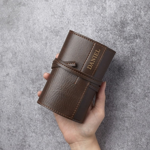 Personalized Tech Case Cable Charger Organizer in brown leather with name 'DANIEL' embossed on it, held in hand.